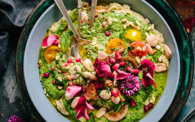 Dish with avocado and tomatoes garnished with pink flowers